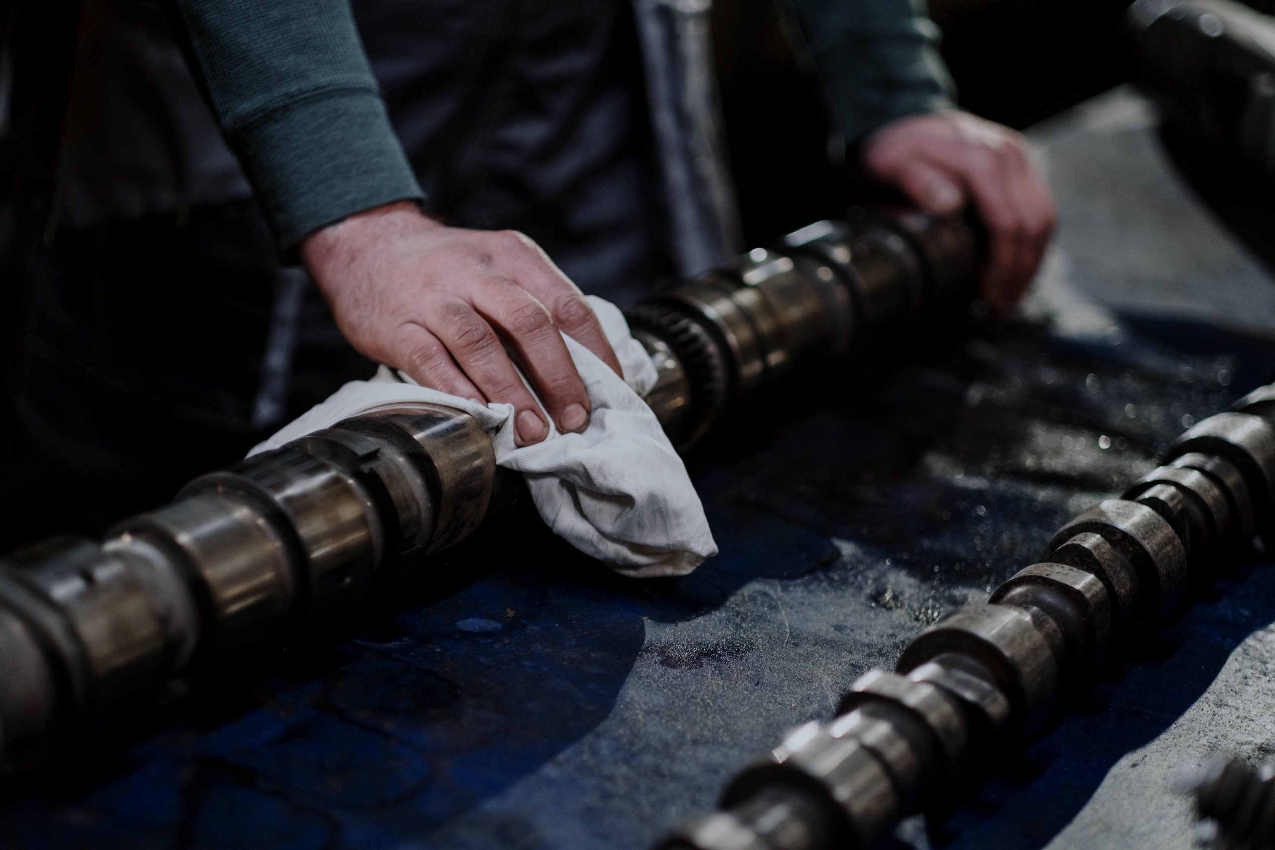 Worker handling a camshaft in a workshop
