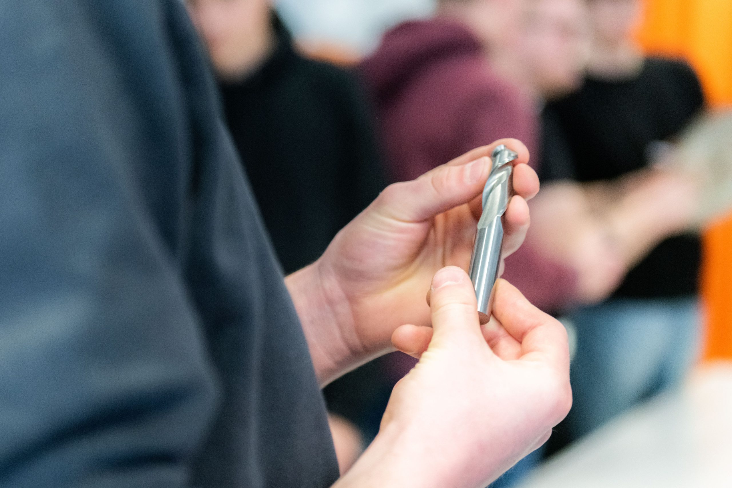 Small metal component being reviewed by hand