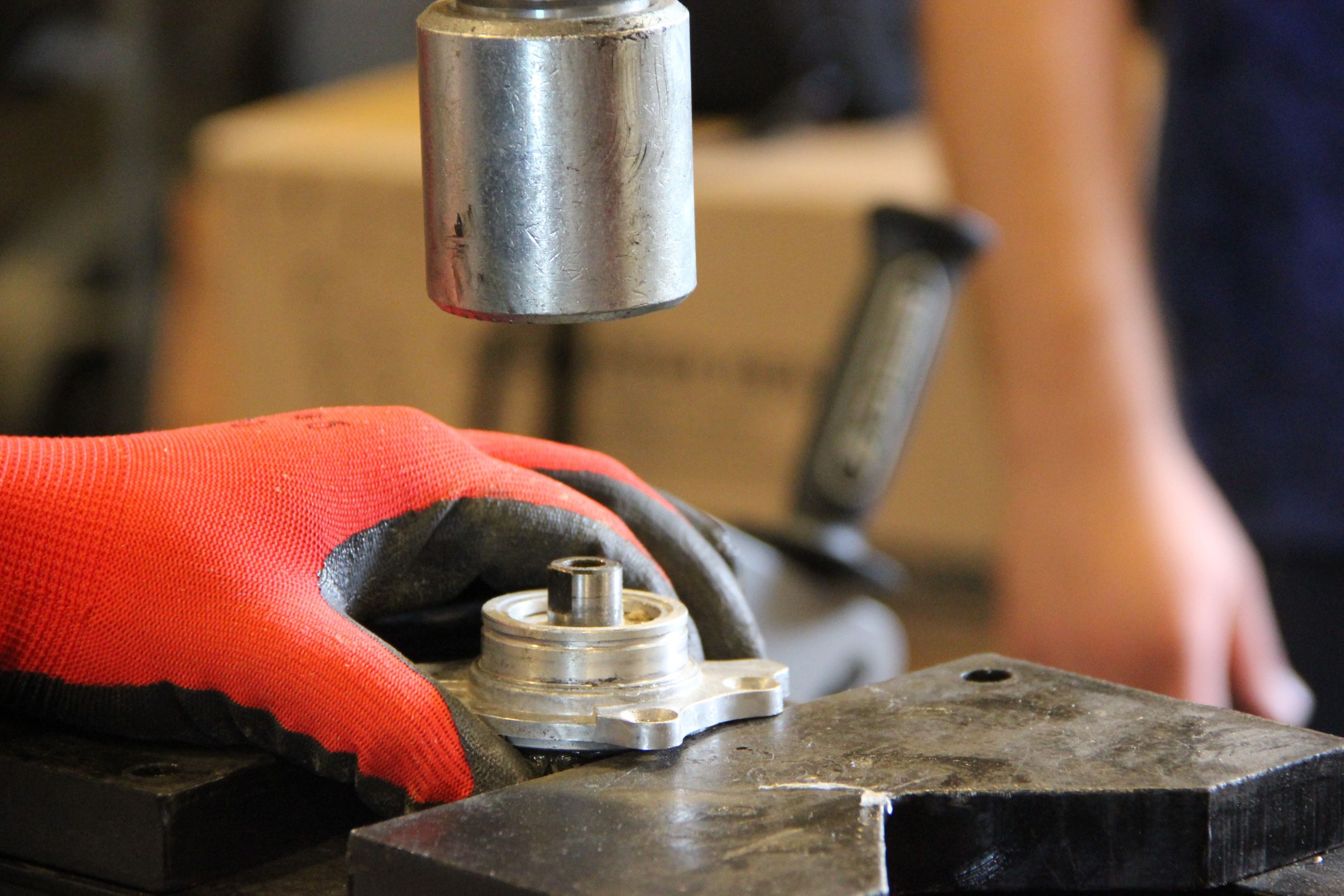 Hands reviewing an industrial metal component during manufacturing